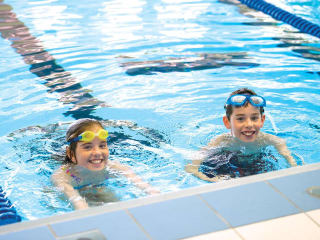 Child swimming and practicing strokes in the pool at Chelsea Piers Brooklyn summer swim camp