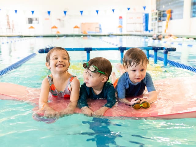 Young kids in the pool with goggles during a swim session at Imagine Swimming's Crown Heights camp
