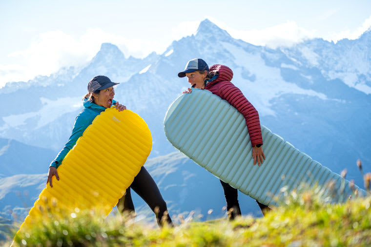 Two backpackers with sleeping pads