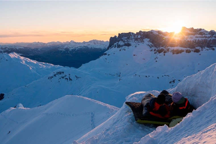 Two backpackers watching the sunset in the snow