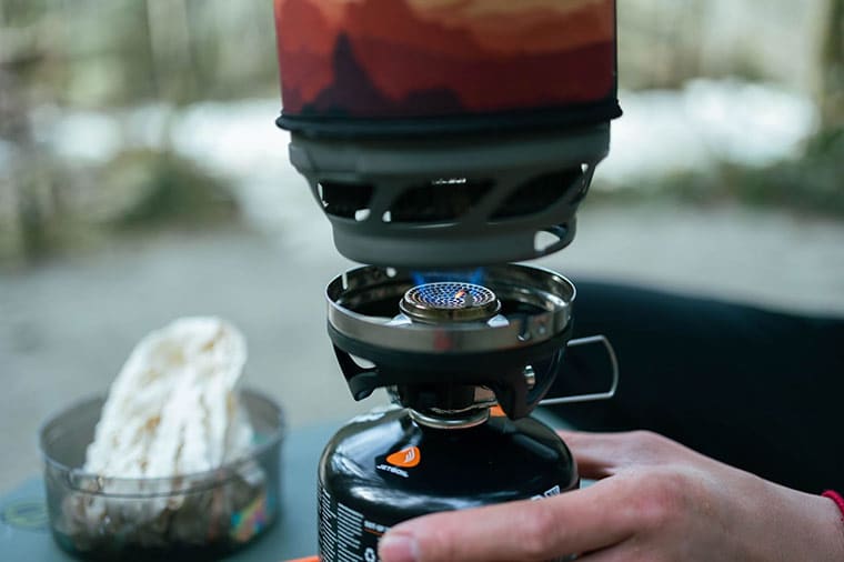 Camping placing the Jetboil MiniMo cooking Cup onto the fuel regulator