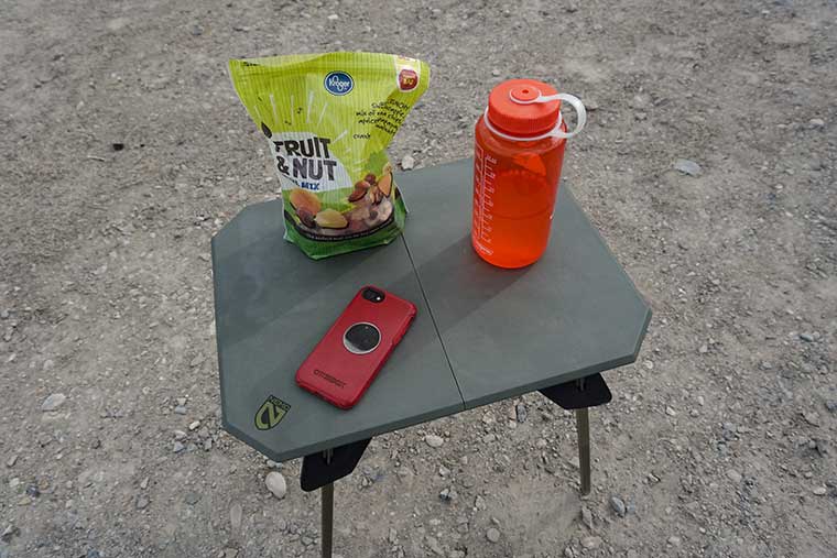 The Moonlander with a bag of snack mix, Nalgene water bottle, and smartphone on top of it.