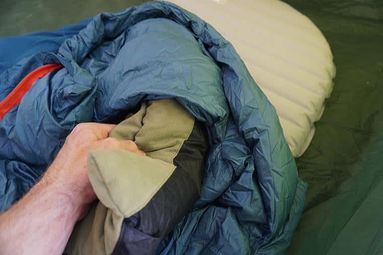 Deflated camp pillow being put into the pillow barn