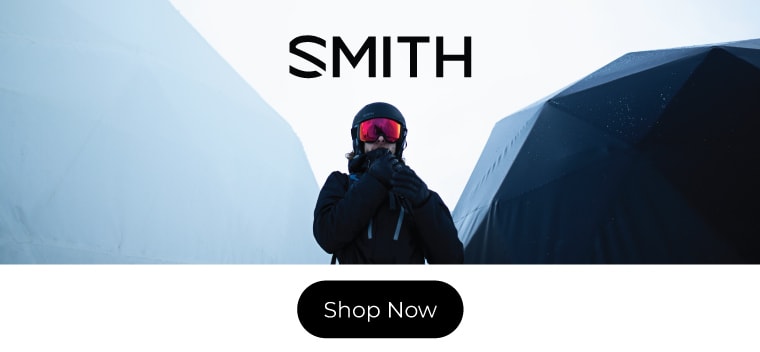 man in ski equipment standing underneath Smith logo