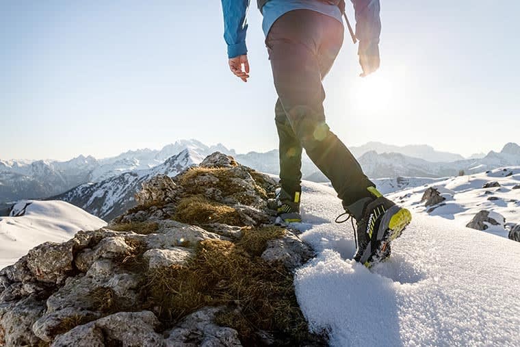 Hiker on a snowy ridge wearing the Rush Trk GTX Hiking Boot