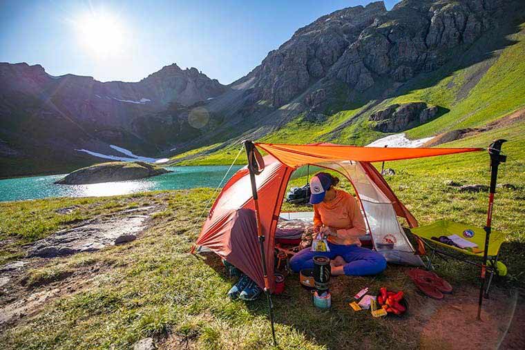 A camper sitting under the awning of the Big Agnes Copper Spur HV UL2 vestibule