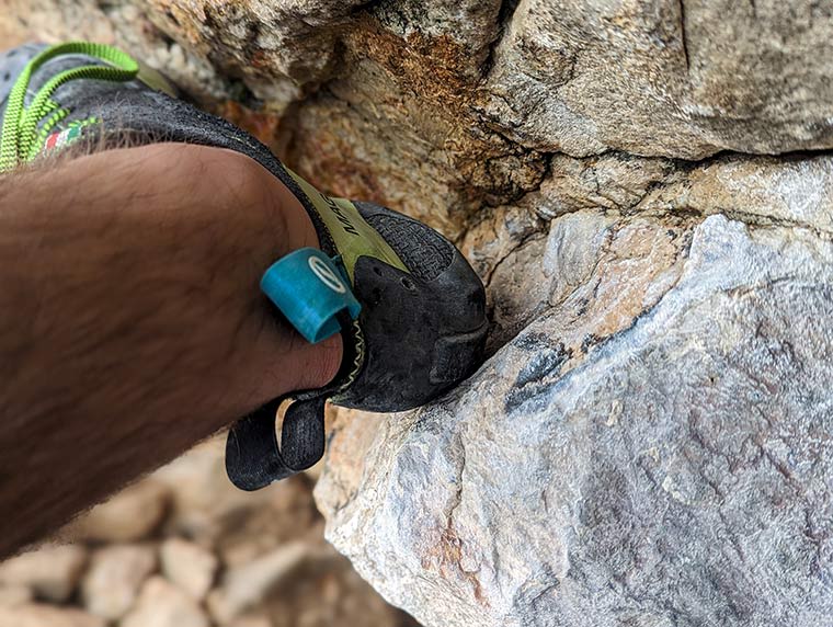 Close up on the Mago while being used to heel hook on the rock