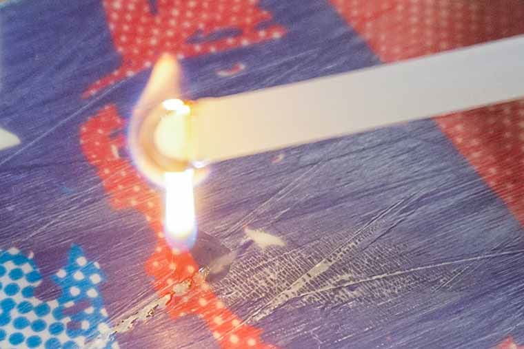 Flaming PTex stick dripping into a damaged ski base