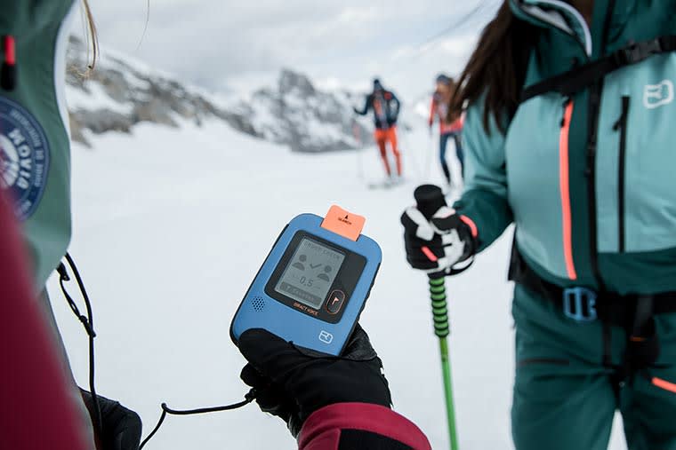 Skier using the Ortovox Diract Avalanche Beacon's group check feature.