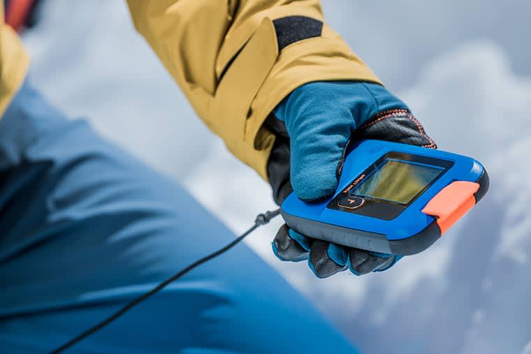 Skier using the Diract Voice Avalanche Beacon in search Mode