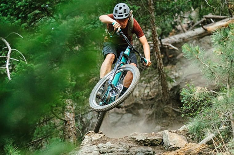 mountain biker jumps over a downed tree