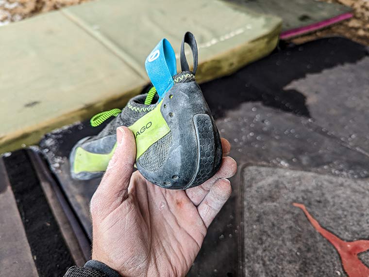 Hand holding the Mago showing the heel cup of the climbing shoe 