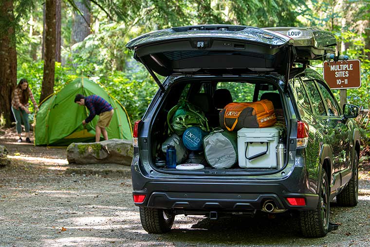 Campers setting up a tent near their car