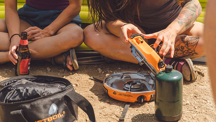 Camper opening the Jetboil Genesis, highlighting the compact design.