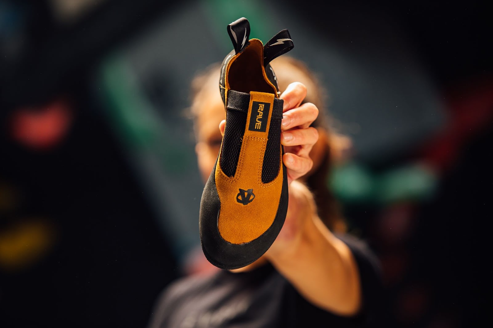 A climber holding up the Evolv Rave climbing shoe