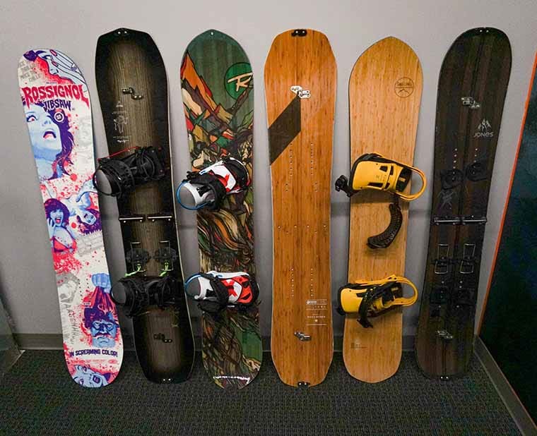 Six snowboards leaned against a wall