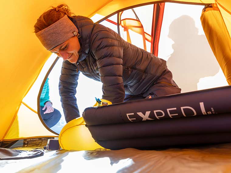 Camper inflating the Exped Versa Sleeping Pad