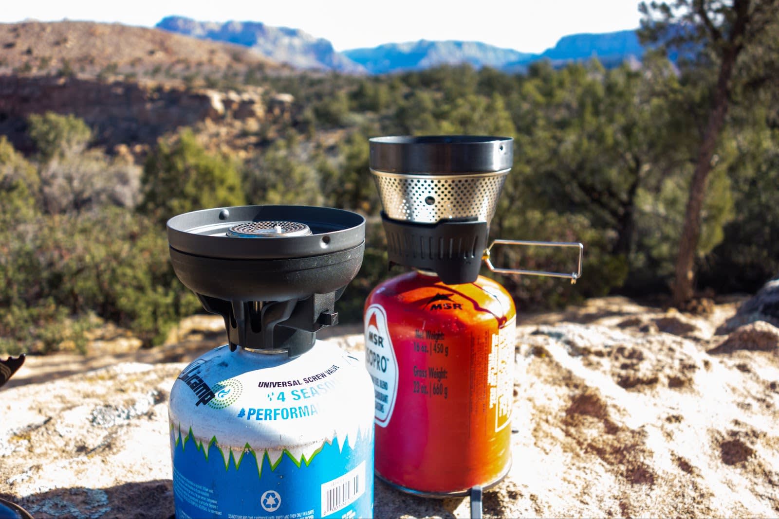 The Jetboil Flash and MSR Windburner regulators on fuel cans side by side