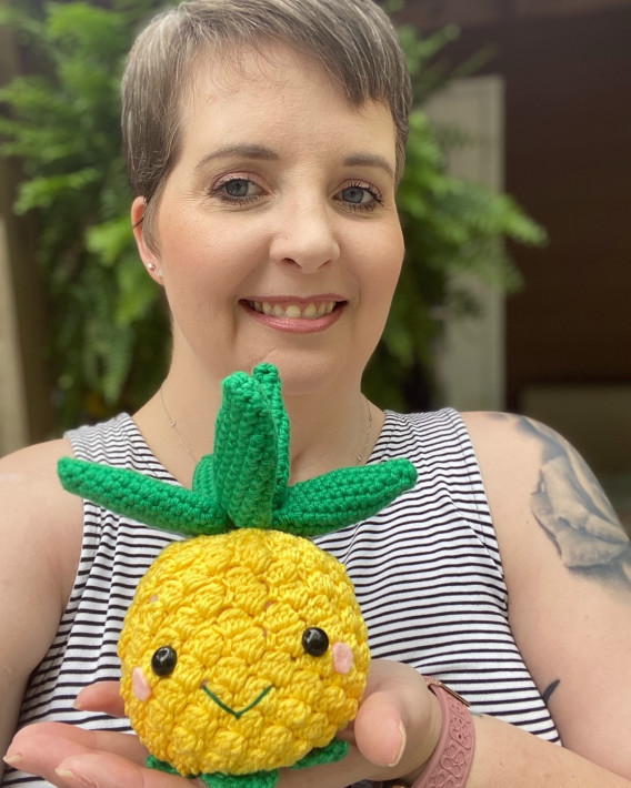 Christy Bullock holding a crochet pineapple