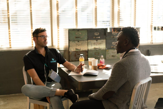 Two people sitting at a table talking.