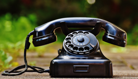 Black rotary phone on an outdoor surface