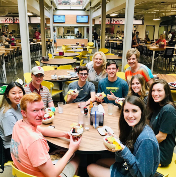 Students gathered around a table in the Commons Dining Hall