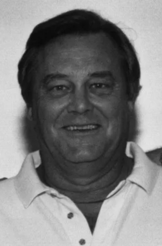 A black and white photo of a man smiling