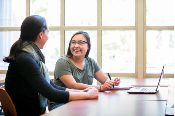 Academic advisor and a student at a desk in University of the Pacific's academic services hub.