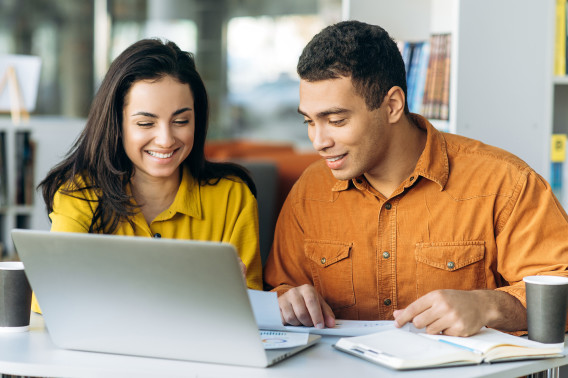 A mentor and mentee work together in the library; student mentorship opportunities