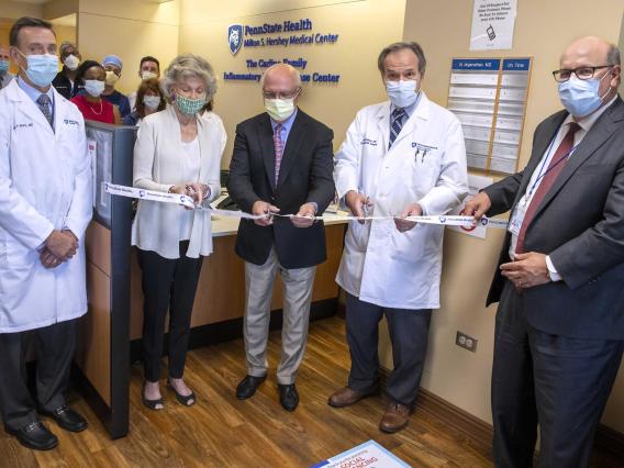 Dr. Walter Koltun, Marshia and Peter Carlino and Carlino Family IBD Center director, center, cut the ribbon to dedicate the newly named center, surrounded by Dr. Kevin Black, interim dean of Penn State College of Medicine, left; Penn State Health CEO Steve Massini, right; and other faculty and staff of the Carlino Family IBD Center. Credit: Penn State Health. All Rights Reserved.