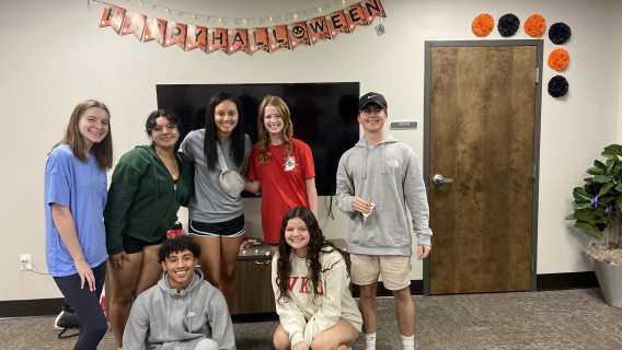 CHHS Living Learning Community pose in front of Halloween decorated pod