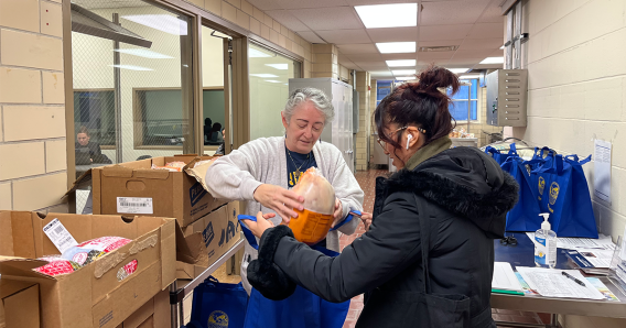 Frank loads a frozen turkey for student pick-up at The Basket.