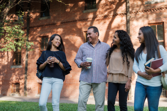 A father surrounded by his daughters, smiling