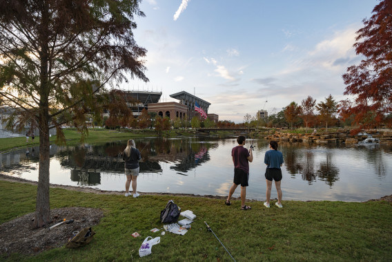 students fishing at aggie park at sunset 