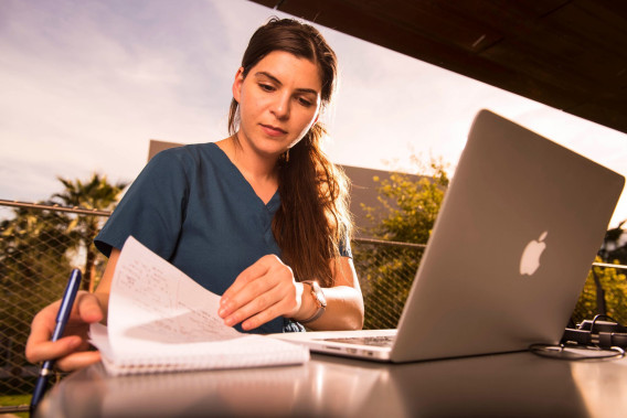 Student looking at notes next to their laptop