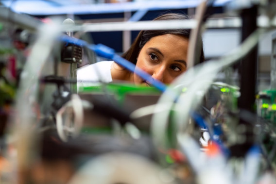 Female space operations engineer inspects rover components