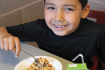 Indigenous boy eating a school breakfast