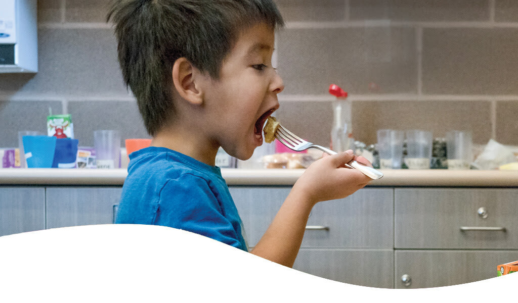 Indigenous boy eating a school meal