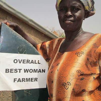 Madam Azuma stands with her Overall Best Woman Farmer award