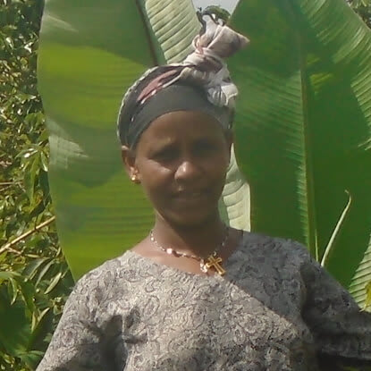 Berhane, a female farmer from Ethiopia, stands in front of a banana tree