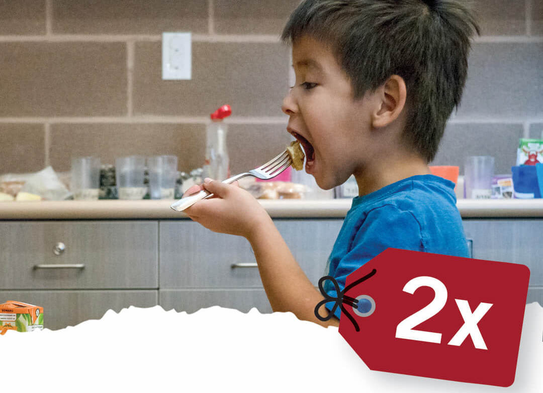 Charity Gifts Canada include school meals. Image shows First Nations boy enjoying his school breakfast.