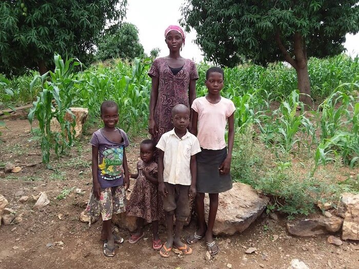 Prudence stands outside together with her four children