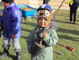 Young Indigenous girl holds a potted plant