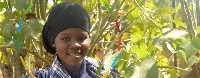 Fatima smiles as she stands in amongst trees