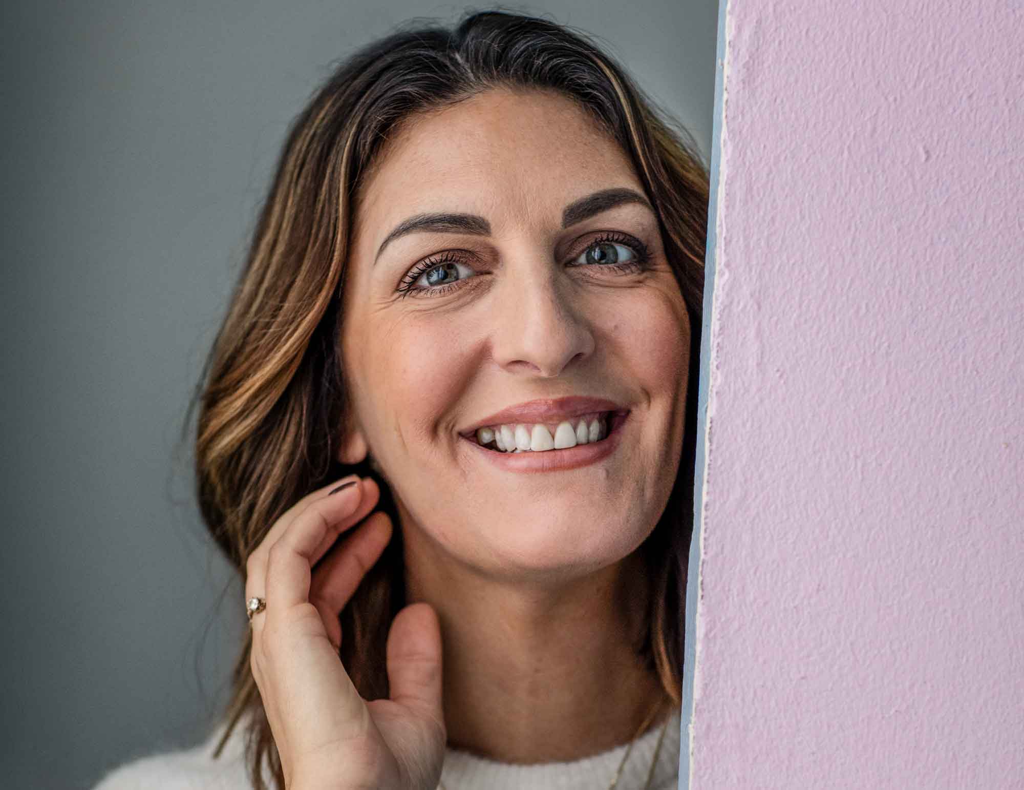 Soraya Lavasani står vid en rosa vägg