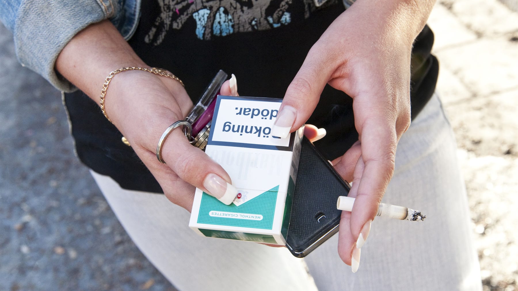 Två händer som håller i ett cigarettpaket