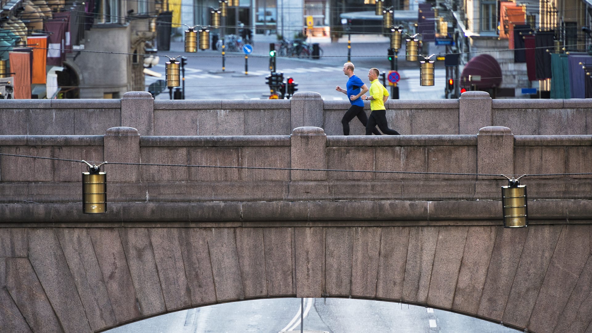 Två män joggar över en bro