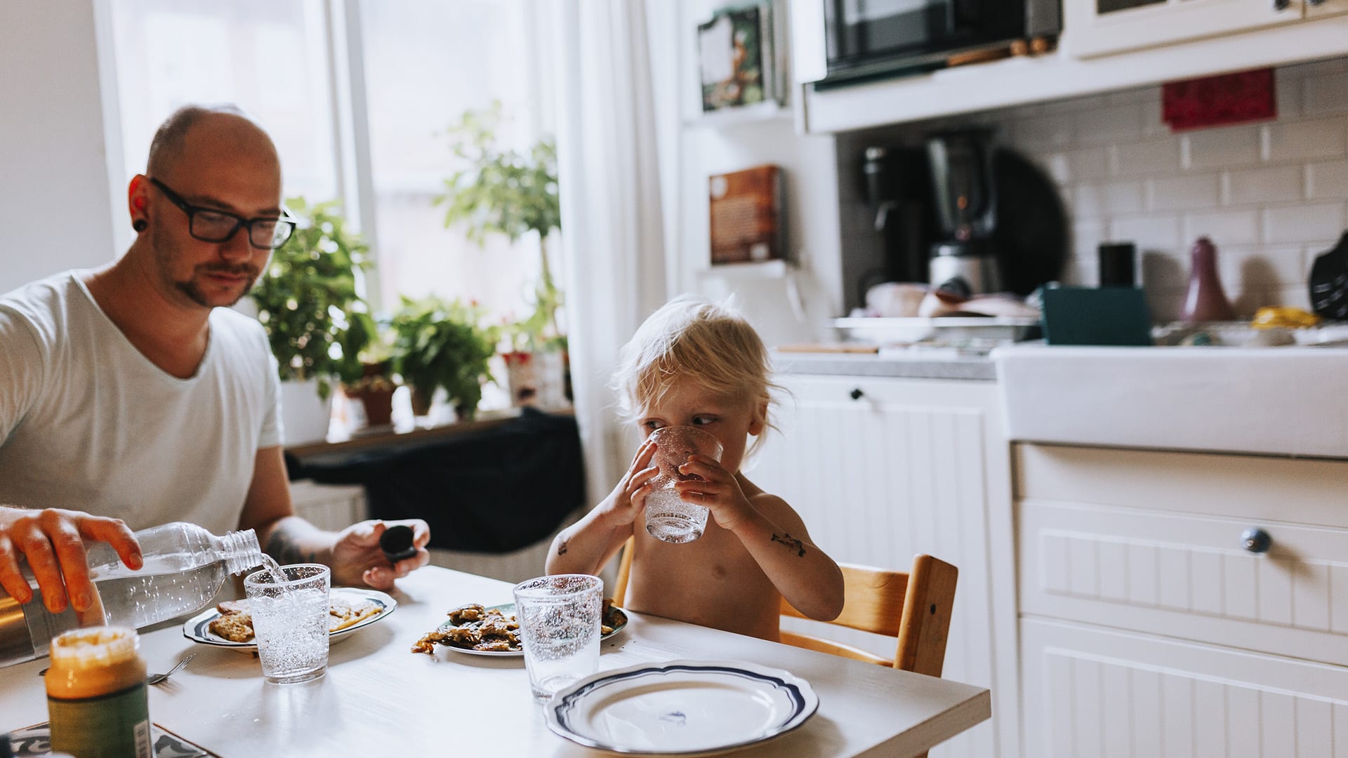 Ett barn sitter vid matbordet tillsammans med sin pappa