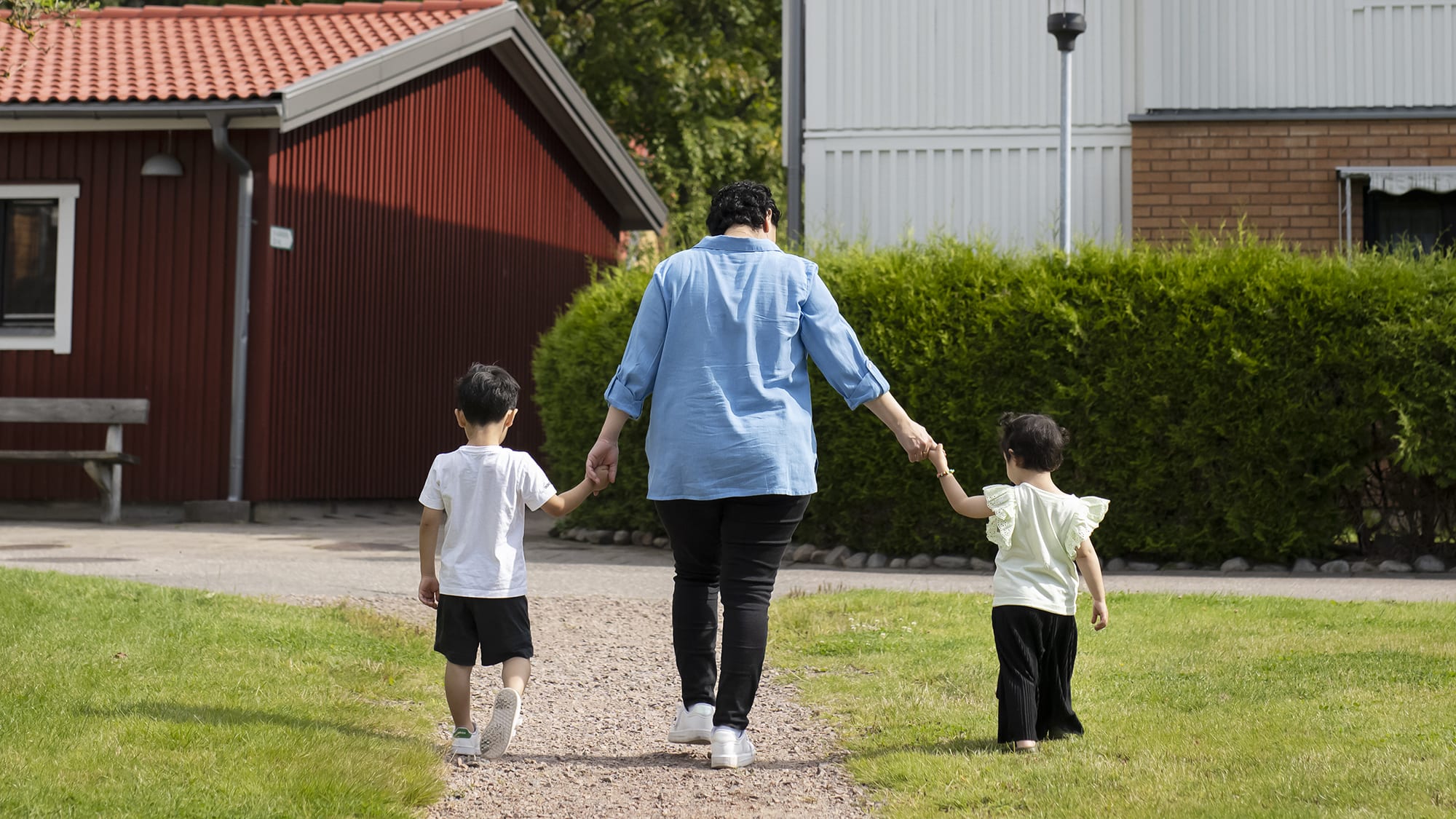 Bild tagen på avstånd och bakifrån på Neda och hennes två små barn. Foto: Julia Sjöberg.