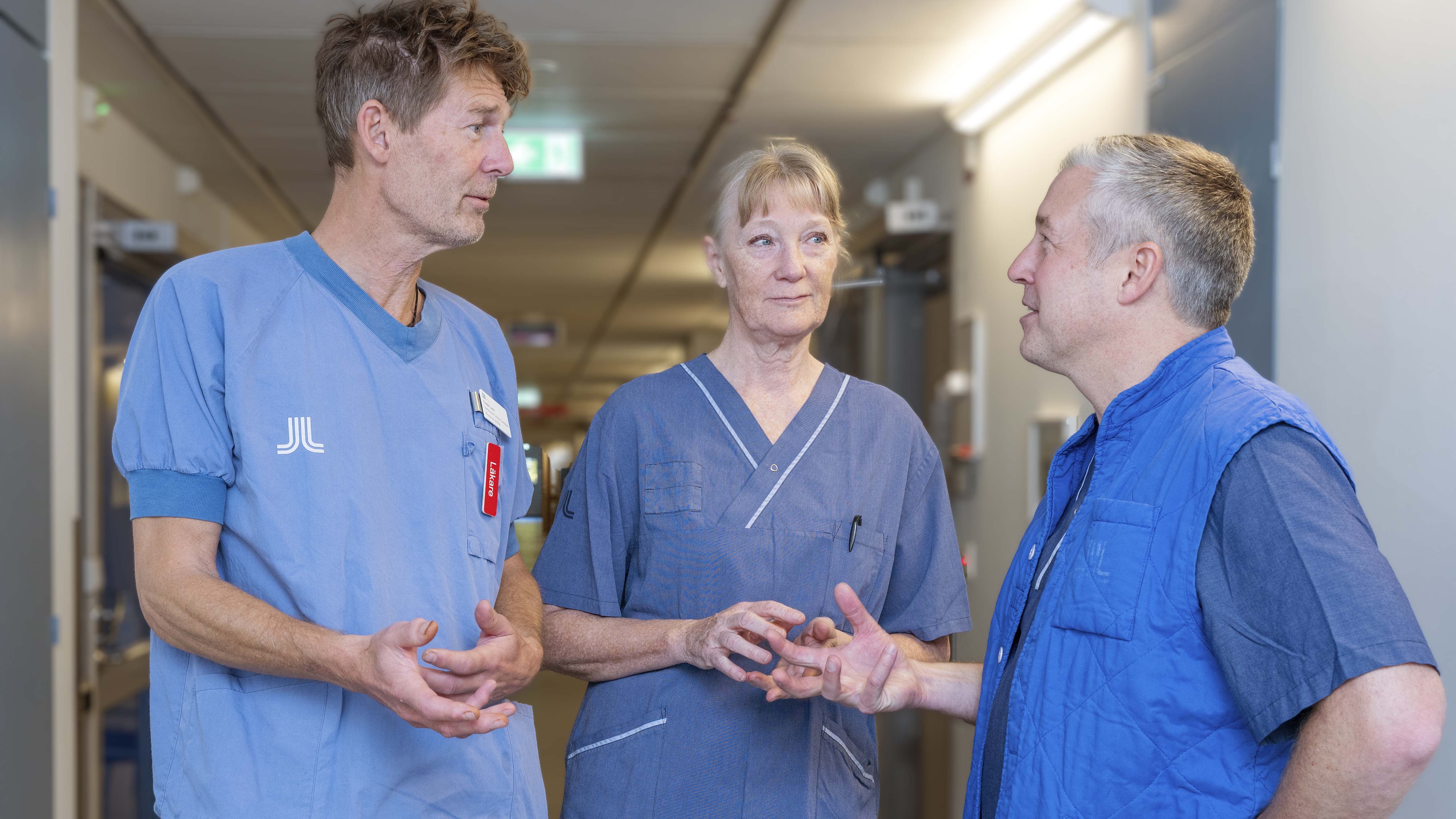 tre vårdpersonal i sjukhuskorridor